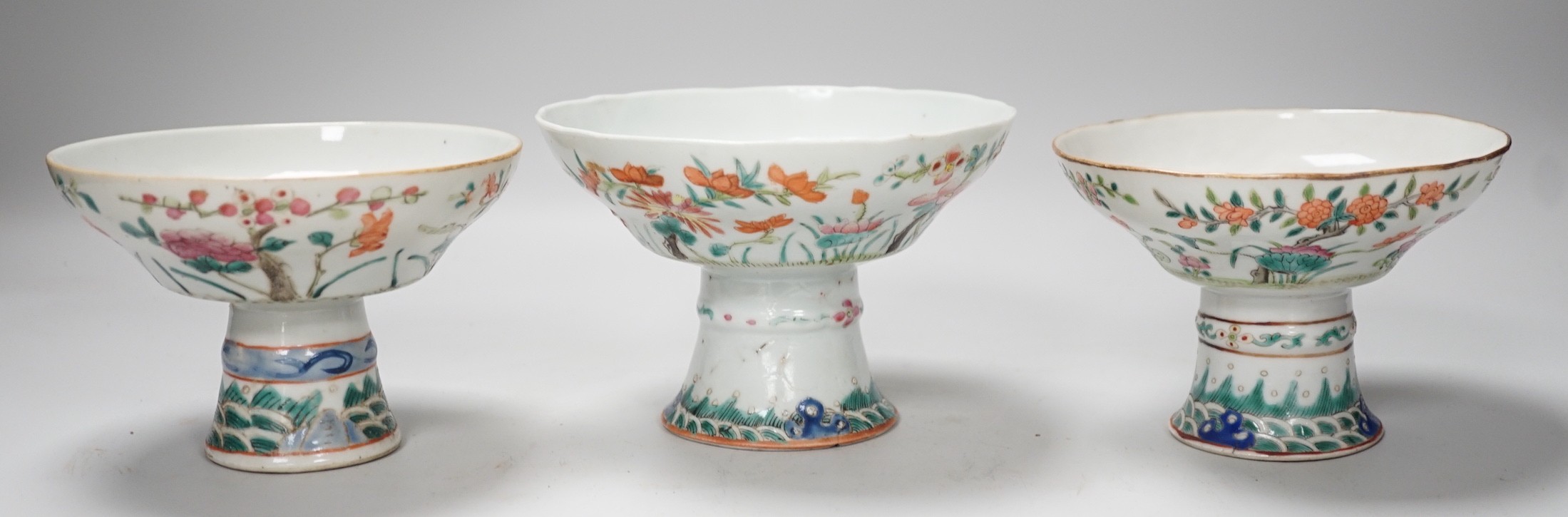 Three 19th century Chinese famille rose pedestal stem bowls, each painted with flowers and foliage, 9.5cm tall
